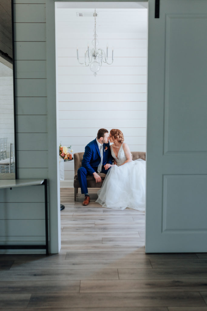 a couple sharing a private kiss on their wedding day at the farmhouse wedding event in houston texas captured by joanna booth weddings