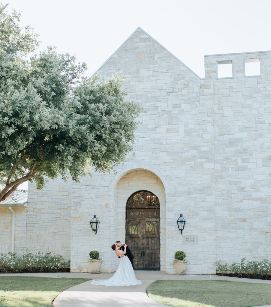 Joanna Booth weddings captures the bride and groom outside of the briscoe manor in Houston texas having a first kiss on wedding day